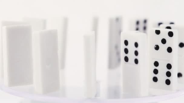 Dominoes with black dots stand vertically on glass and rotate — Stock Video