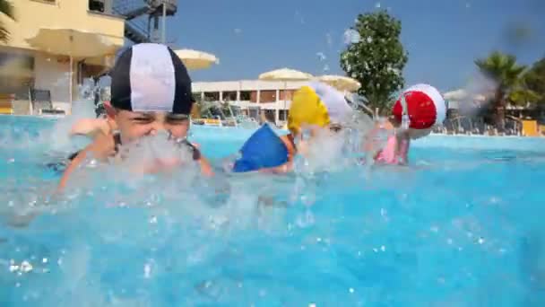 Мальчики и девочки в плавательных шапках брызгают водой — стоковое видео