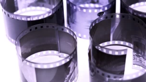 Rouleaux de film négatif noir et blanc tournent sur la surface lumineuse 