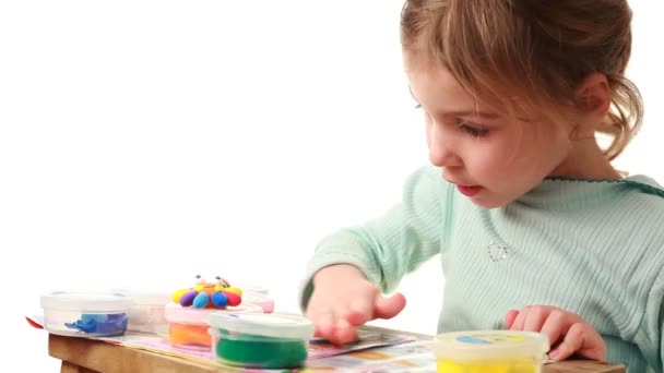 Niña rollos en la mesa pequeña bola de plastilina — Vídeo de stock