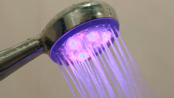 Wasser fließt aus Gießkannen-Dusche mit beleuchteten farbigen Lichtern — Stockvideo