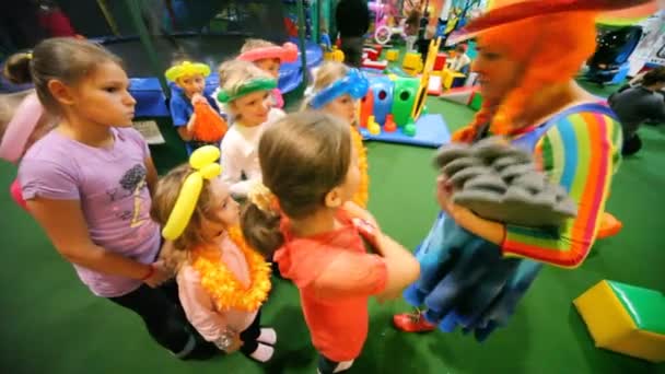 Pajac daje Sprzęt dla dzieci w klubie dla dzieci, małe miasteczko dla dzieci — Wideo stockowe