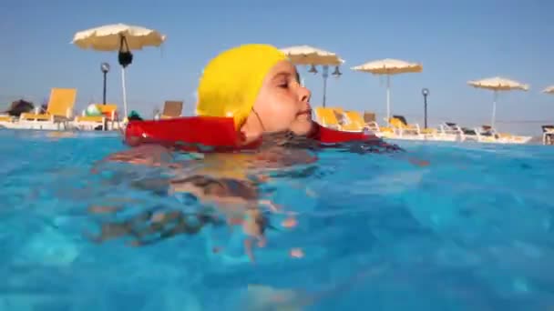 Menina nada na piscina, em seguida, se aproxima da mãe e brinca com ela — Vídeo de Stock