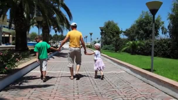 Man with daughter and son go on walkway to hotel — Stock Video