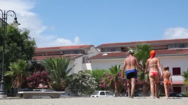 Parents and their son are walking away by street, then girl catches up with them — Stock Video