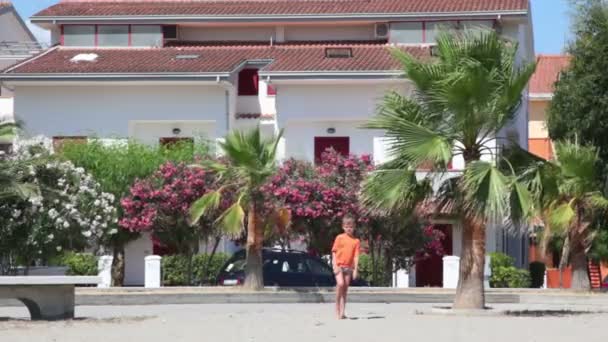 Menino correndo mais perto pela rua de areia no verão — Vídeo de Stock