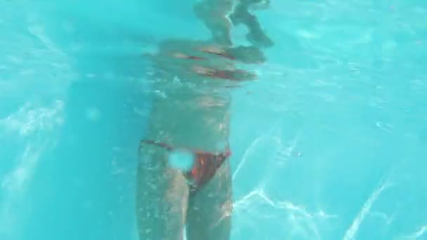 Mamma håller dotter händer och doppar henne in i poolvattnet — Stockvideo
