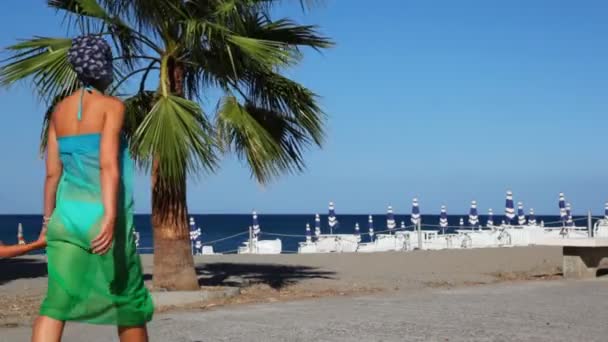 Nő a lányával elhagyják strand közelében a tenger mentén — Stock videók
