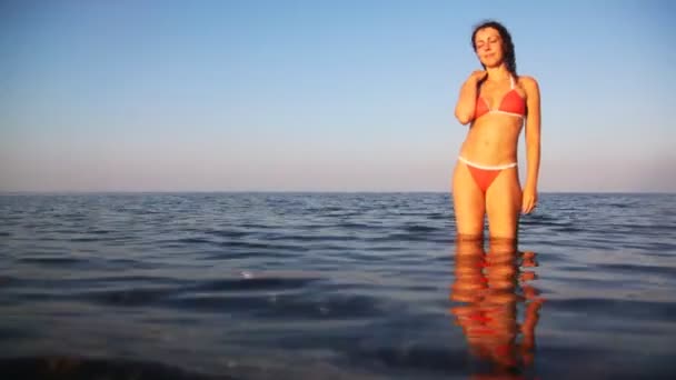 Linda chica se para hasta las rodillas en el mar — Vídeo de stock