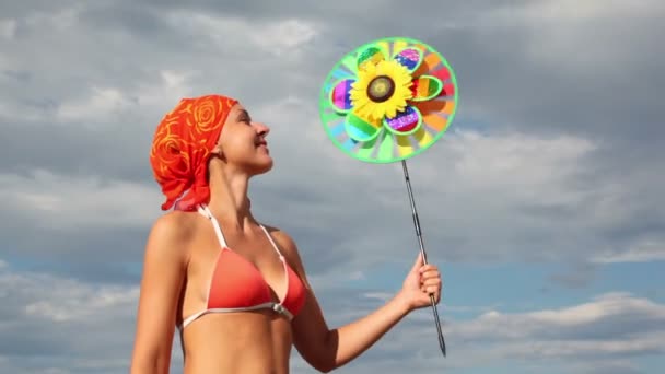 Vista de cerca de una mujer sosteniendo un juguete que gira sobre el fondo del cielo — Vídeo de stock