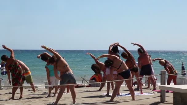 Tourists making aerobics on beach — Stock Video