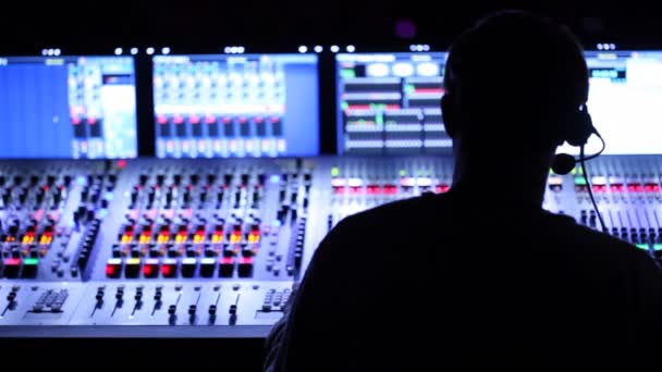 Silhouette of sound producer, which sits at mixer panel — Stock Video