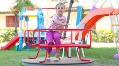 otururken atlıkarınca üstünde küçük bir kız vardı