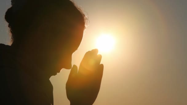 Silhouette of woman head, holding two fists together, then bowed head — Stock Video