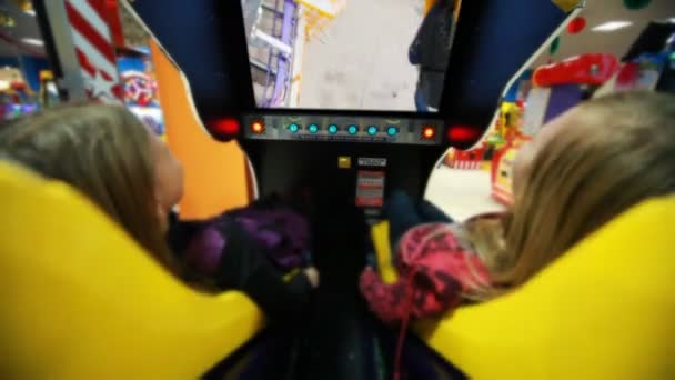 Two girls watch film on motion simulator, screen movie with roller coaster — Stock Video