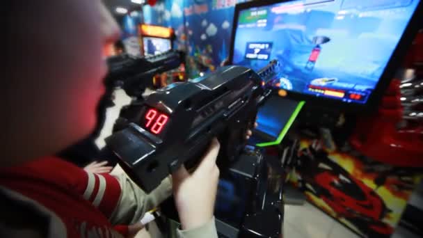 Pojkar spelar intressant rymdspel med pistol på skärmen — Stockvideo