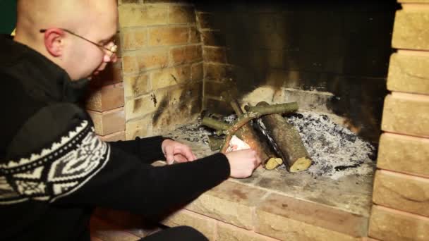 Człowiek rozpalić ogień w kominku — Wideo stockowe
