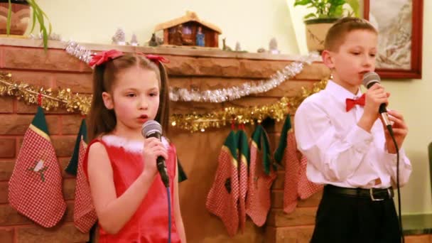 Sorella e fratello ballano e cantano canzoni in microfono, Natale — Video Stock
