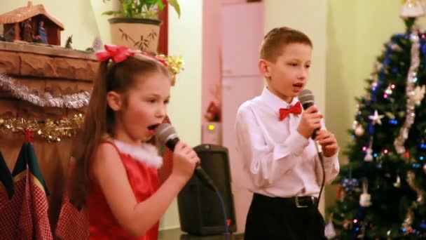 Брат і сестра співають пісню на мікрофон — стокове відео