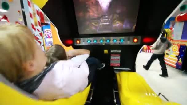 Mother holding child and watch interesting film on motion simulator — Stock Video