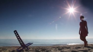 kadın geldi, sit ve şezlong arkasına yaslandı