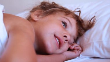 sevimli küçük kız yastık üzerinde uyandırmak çalışan biri