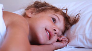 sevimli küçük kız yastık üzerinde uyandırmak çalışan biri