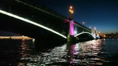 neva üzerinde duran ışıklı demir köprü altında geceleri kamera hareket