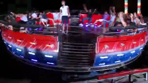 People rotating on platform of tagadance amusement — Stock Video