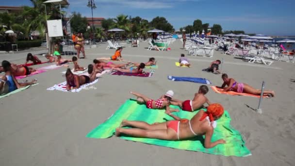 Skupina lidí ležel na pláži a studium jógy — Stock video