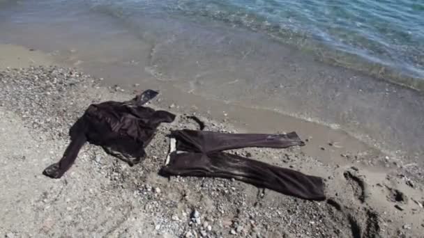 Hnědý oblek ležel na písku poblíž mořské vody — Stock video