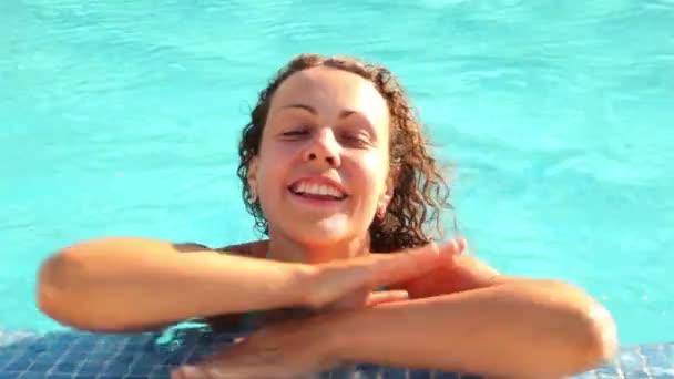 Woman laying in wavy pool water and moving her legs — Stock Video