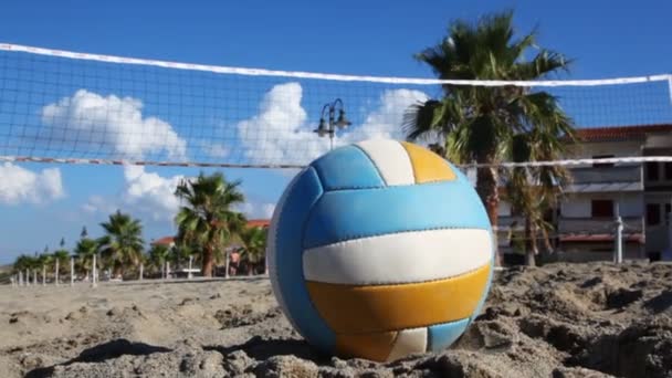 Bola se encuentra en la arena bajo la red de voleibol en la playa — Vídeo de stock
