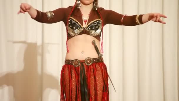 ženské tanečník v hnědé šaty s nožem provádí na scéně