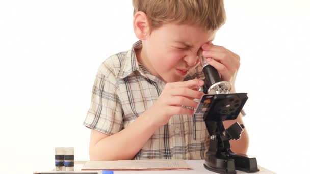 Kleine jongen kijkt naar de Microscoop en het opzetten van — Stockvideo