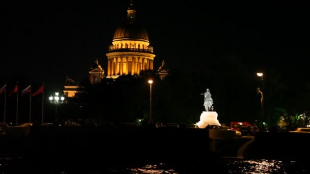 Barco flota por la noche a través de Neva por Isaakievsky catedral y jinete de cobre — Vídeo de stock