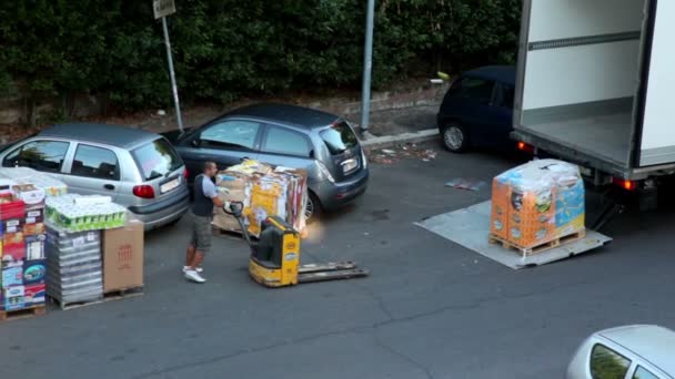 Человек загружает коробки с отходами на погрузчик рядом с новым товаром — стоковое видео