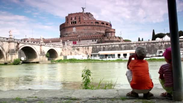 Zwei Kinder Bruder und Schwester sitzen am Ufer des Flusses — Stockvideo