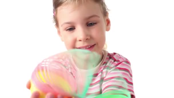 Menina segura brinquedo interessante em ambas as mãos, em seguida, levanta as mãos e coloridos sags espiral para baixo — Vídeo de Stock