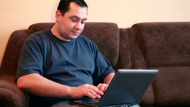 Člověk sedí a píše na jeho notebooku — Stock video