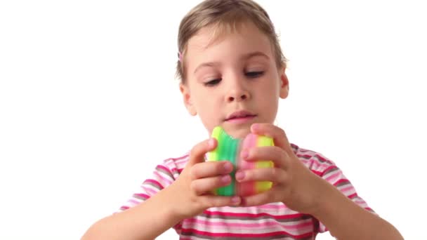 Menina segura brinquedo interessante em ambas as mãos, em seguida, levanta as mãos e coloridos sags espiral para baixo — Vídeo de Stock