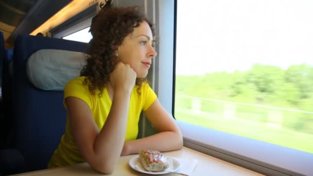 Woman sits in train near window during movement at table — Stock Video