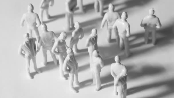 Group of little unpainted toy people stand and drop shadows — Stock Video
