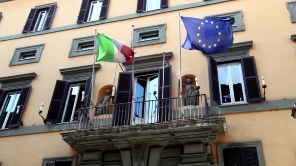 Wall of the building with balcony it is fitted flags of Italy and the EU — Stock Video