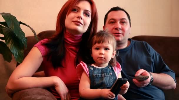 Los padres y su bebé están viendo la televisión — Vídeo de stock