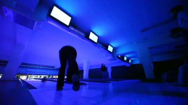 La gente juega a los bolos en la oscuridad, iluminado con luz azul, club — Vídeos de Stock