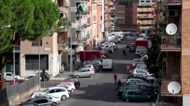Town street from above, many cars parked on each side, pedestrians walk — Stock Video
