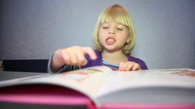 küçük sarışın kız resimleri kitap olarak görüyor.