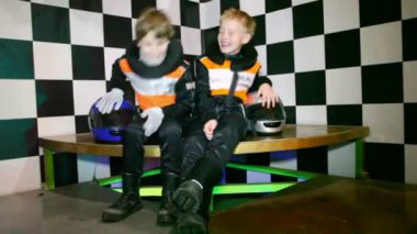 çocuklar üniformalı go-cart yarışları için oturup, yarışları başında beklemek