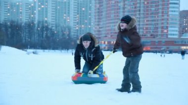 genç çocuk kızak neredeyse diğer çocukla çekme